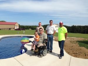 Medically retired Marine Cpl. Justin McLoud and his son Desmond pose by their new pool built by Wideman Pools of Festus, Mo. From left: Dennis Wideman, Rodney Wideman and Doug Ortman, of Ortman Concrete, who donated a portion of the patio.
