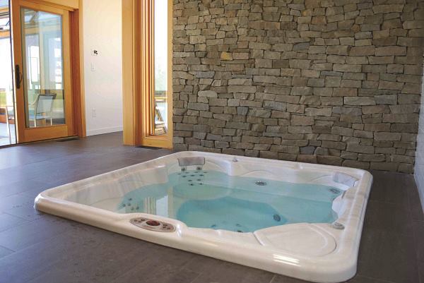 This project is located on Tilghman Island in Maryland where inclement weather puts a damper on outdoor soak sessions. That’s why the homeowners opted for a hot tub sheltered from the elements. However, it was important that the spa environment connect to the outdoor living space. “They wanted the wide-open feel, but indoors for year round use,” explains Danny Morris, general manager of AQUA Pools & Spas in Easton, Md. Sliding glass doors give way to a stunning view a 44-foot long geometric pool just off the deck outside. This spa room also includes a shower and a sauna with a unique flooring material that Morris described as “rubberized slate.” It’s a nonslip surface, a wise safety feature.