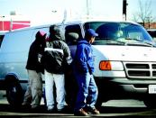 Immigrant workers solicit a would-be employer at an informal day labor gathering spot. While many day laborers have had access to formal education in their native countries, their lack of English fluency—and, in many cases, their illegal status—makes career advancement an uphill struggle.