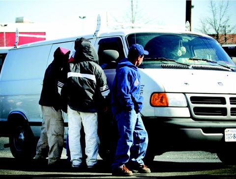 Immigrant workers solicit a would-be employer at an informal day labor gathering spot. While many day laborers have had access to formal education in their native countries, their lack of English fluency—and, in many cases, their illegal status—makes career advancement an uphill struggle.