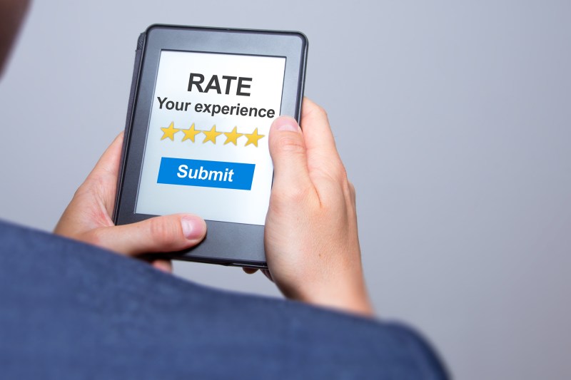 Businessman hands holding tablet with Rate your experience. Business concept.