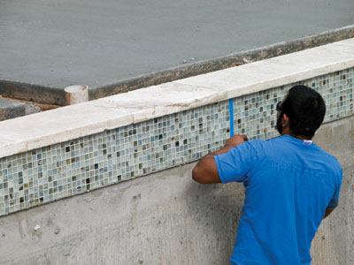 Crews place the joints in waterline tile and on a corner, using a sealant that closely matches the grout in color.