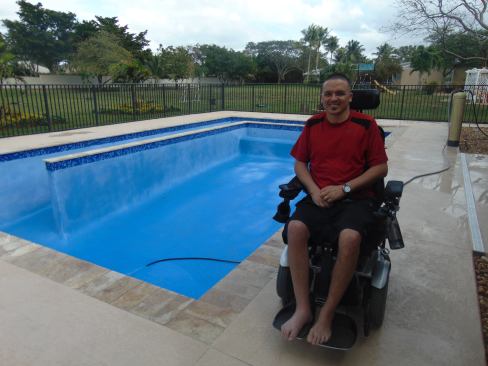 Derek Avilez sits next to the pool he received as a donation from Van Kirk & Sons Pools & Spas anxiously awaiting it to fill with water.