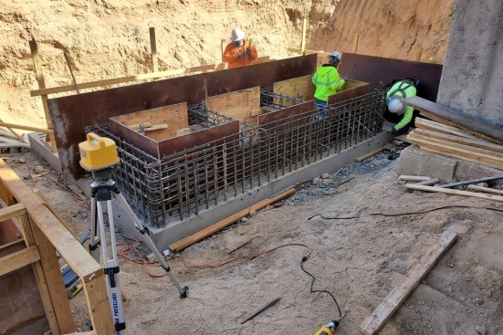 Crews work on the remote surge tank, which broadens significantly below the portion in view here. It reaches 30 feet below grade. Above it will sit the main pool.