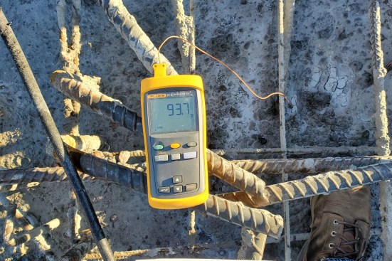 A meter connected to thermocouples monitors the temperatures of the concrete surface and interior.