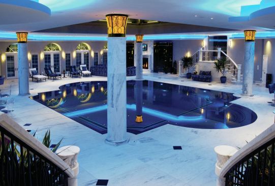 One of a kind: HGTV was eager to film this sophisticated, Mediterranean-looking indoor pool by B&B Pool and Spa Center. Overhead is a scaled replica of the glass pyramid that sits above the Louvre in Paris. Nice touches include 24-carat gold tiles on the pool floor, a movie-house-sized TV screen and several smaller screens on the pool house walls, a bar area with beer taps and café tables, a fireplace area with comfy couches and chairs, and a heated spa.