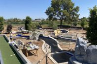 The lazy river in advanced stages  of construction, with the artificial turf pad to the left.