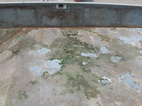 Pulling back the liner reveals a contaminated pool floor, possibly the result of a high water table. 