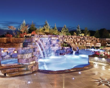 FLOWING DESIGN: To meet the homeowner’s demands, Emmerson trimmed down the sides of a compact pool and merged it with two tanning ledges. A shallower ledge on one side provides a wading area for the family’s three children. A second, crescent-shaped ledge was attached on the other side of the pool and cut along its front face to create a spillover waterfall into the pool.