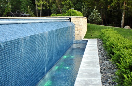 The vanishing edge is made from tile and the vinyl liner restarts in the basin. 